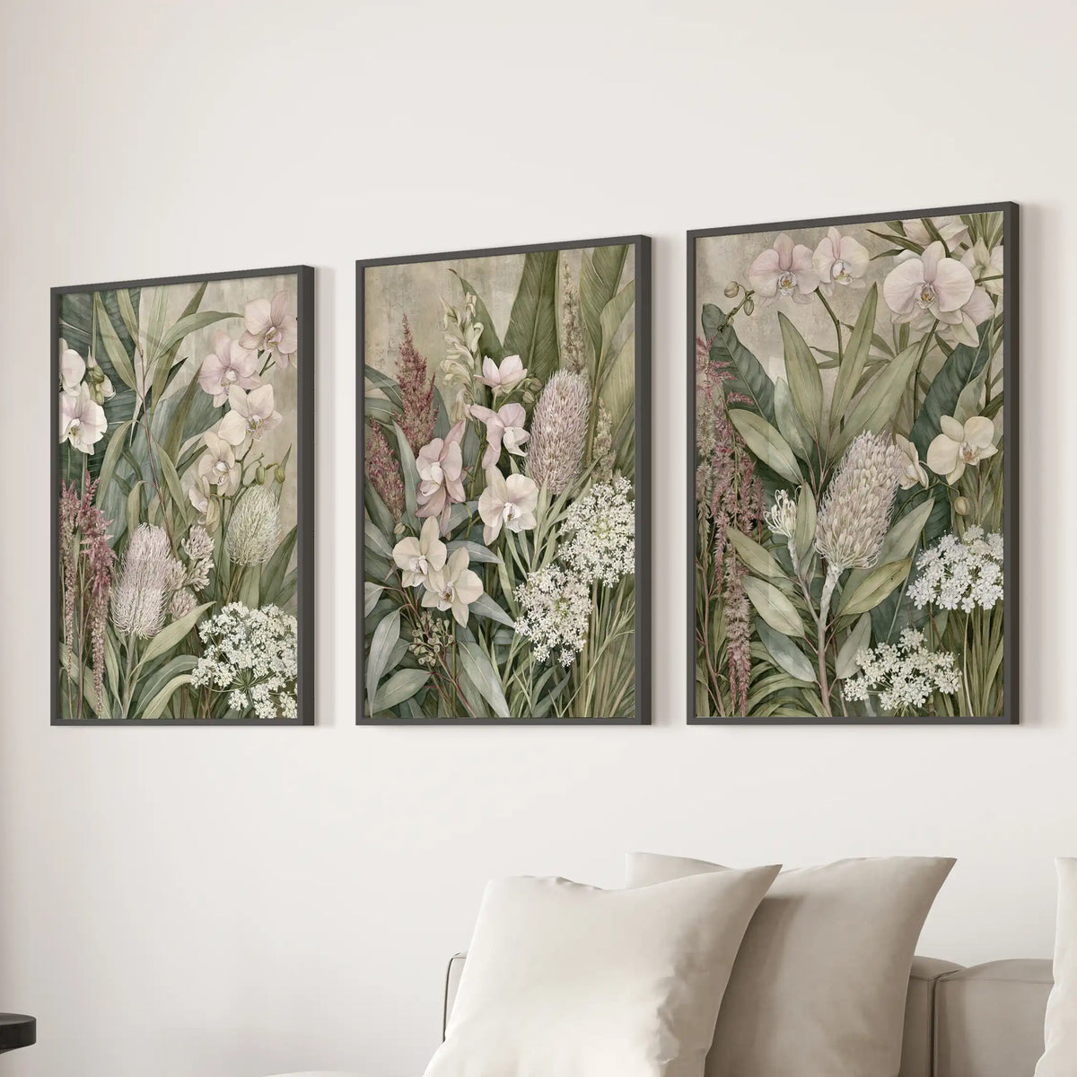 Above a sofa, three black-framed prints display orchids and other tropical flowers.