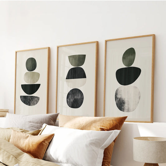 A wood-framed trio of Japandi-style abstract prints brings restful balance to the bedroom, aligned neatly above the headboard.