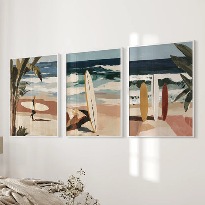 Three surfer-themed wall pieces in slim white frames line the wall beside the bed, adding silhouettes and coastal motion to the room.