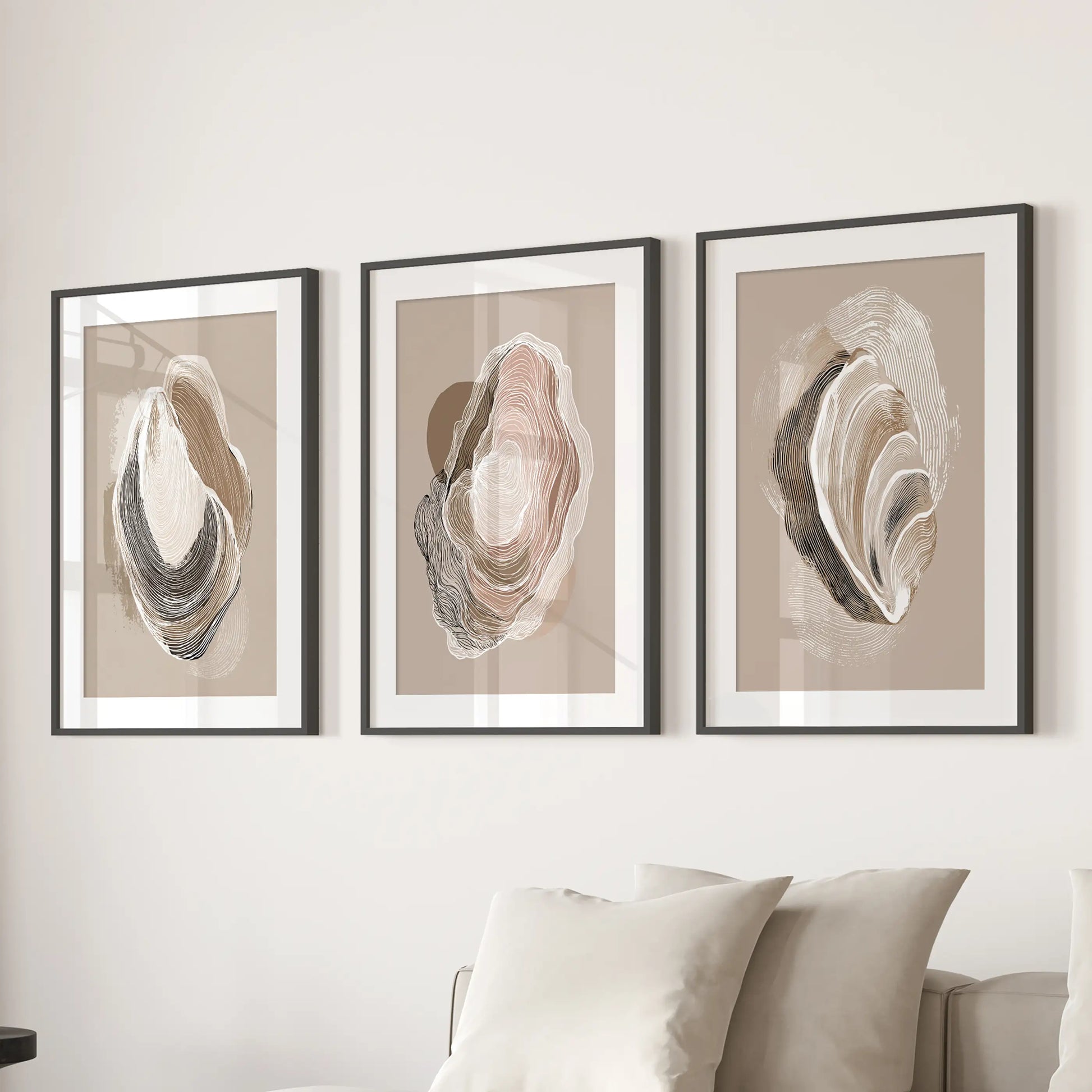 A trio of coastal oyster drawings in matted black frames hangs above the sectional, lending refined seaside texture to the living room.