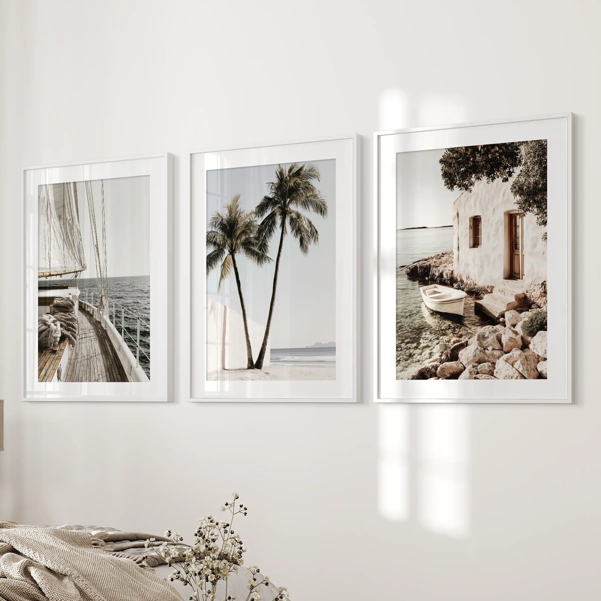 A 3-print wall art set of palm trees in white frames with mats hangs near the bed wall, adding breezy coastal texture to the bedroom.