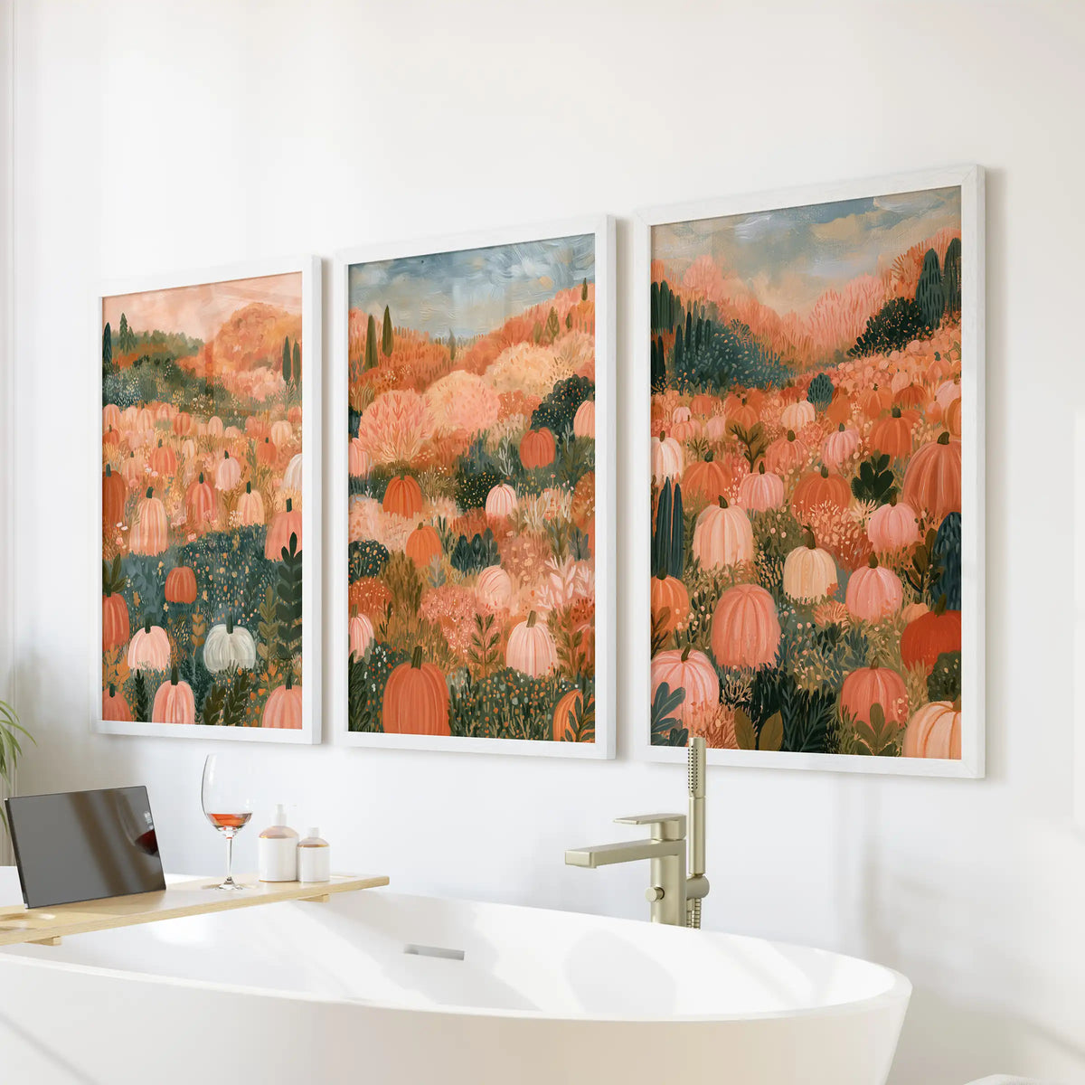 A three-piece wall art set of a pastel pumpkin field in crisp white frames softens the bathroom above the bathtub with airy autumn tones.