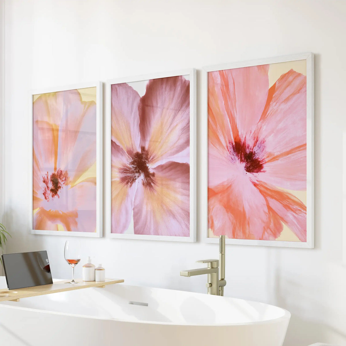 Pink abstract flower wall art in three white frames above a freestanding bathtub.