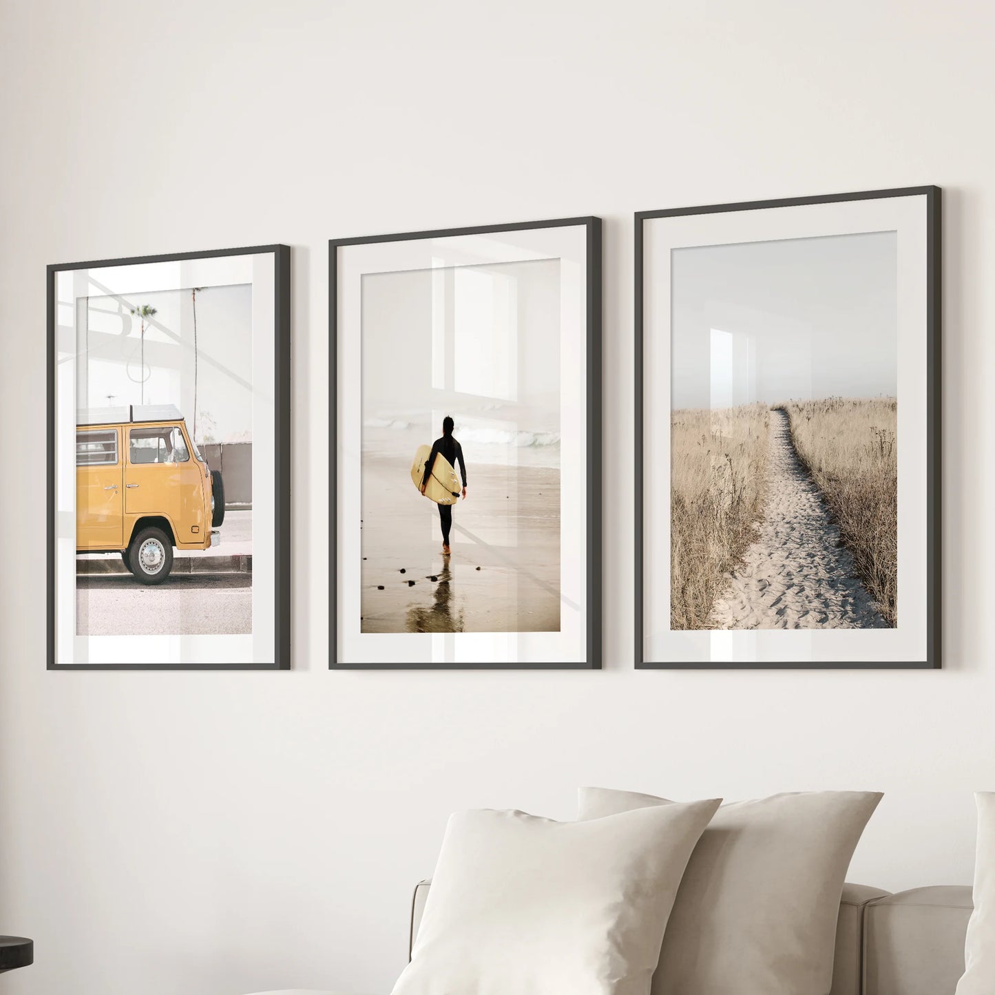 Pastel beach landscapes 3-piece art wall set paired with a black mat frame sits behind the couch, softening the living room with airy tones.