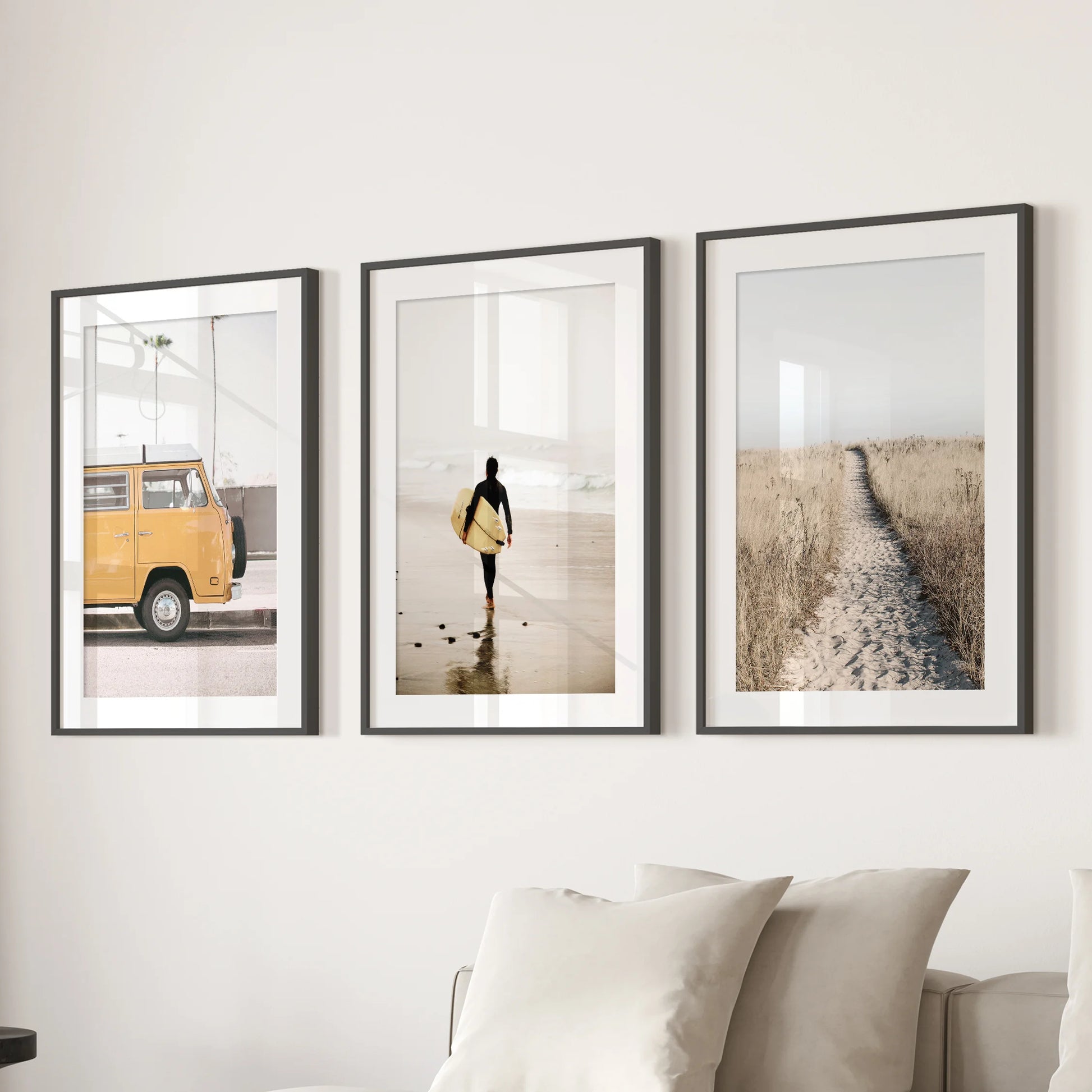 Pastel beach landscapes 3-piece art wall set paired with a black mat frame sits behind the couch, softening the living room with airy tones.