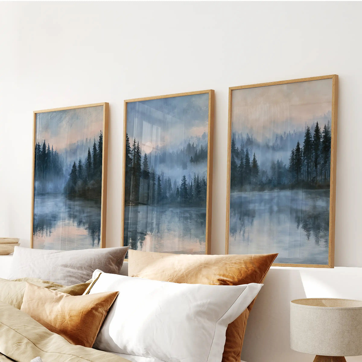 A three-poster wall art set of moonlit blue landscapes in thin wood frames spans the headboard, filling the bedroom with cool night tones and soft depth.