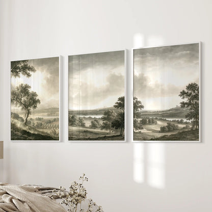 Three-piece pastoral countryside wall art set in white frames, displayed on a bedroom wall.