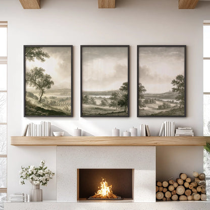 Pastoral countryside wall art in a set of three, displayed in black frames above the hearth in a lounge with a sofa and coffee table.