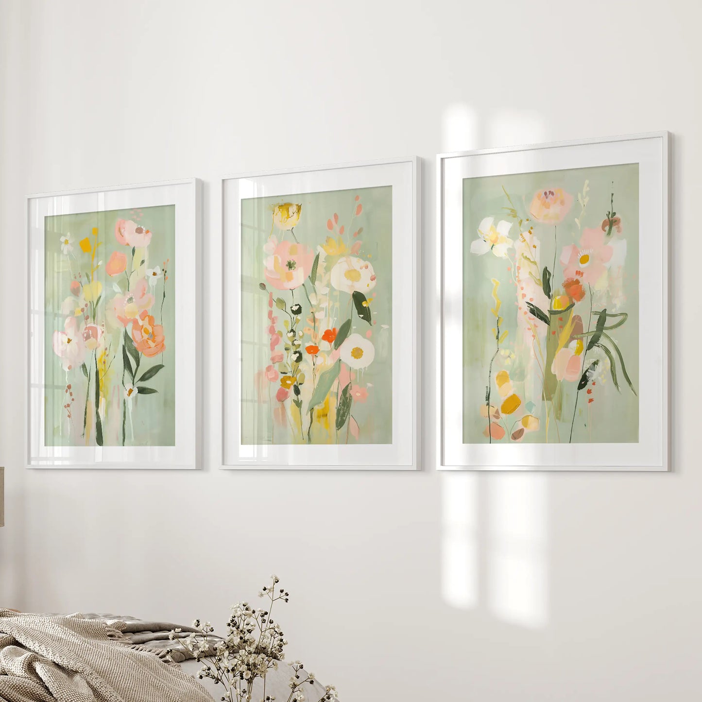A 3-print set of delicate pink and green botanicals in white matted frames softens the bedroom wall near the bed.