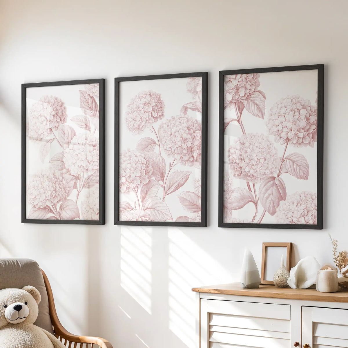 Blush hydrangea prints in black frames, a set of three above a dresser in a kids' room.