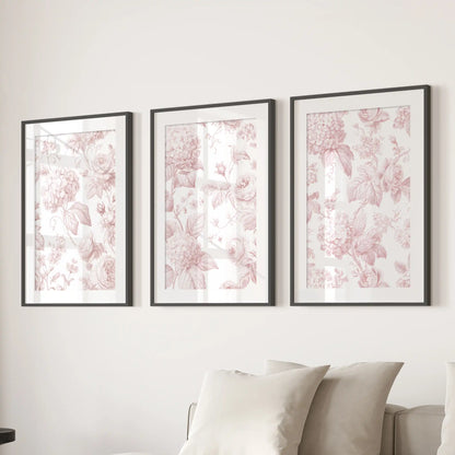 Blush roses, rounded hydrangea clusters and curling leaves fill three prints in black frames with white mats above a sofa.