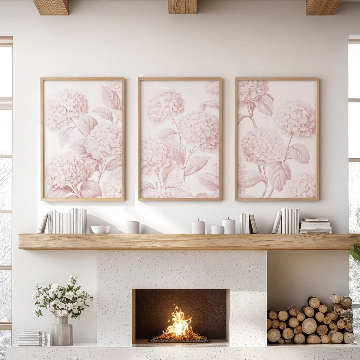 Above a fireplace, oak frames surround three prints of pale pink hydrangeas branching across white backgrounds.