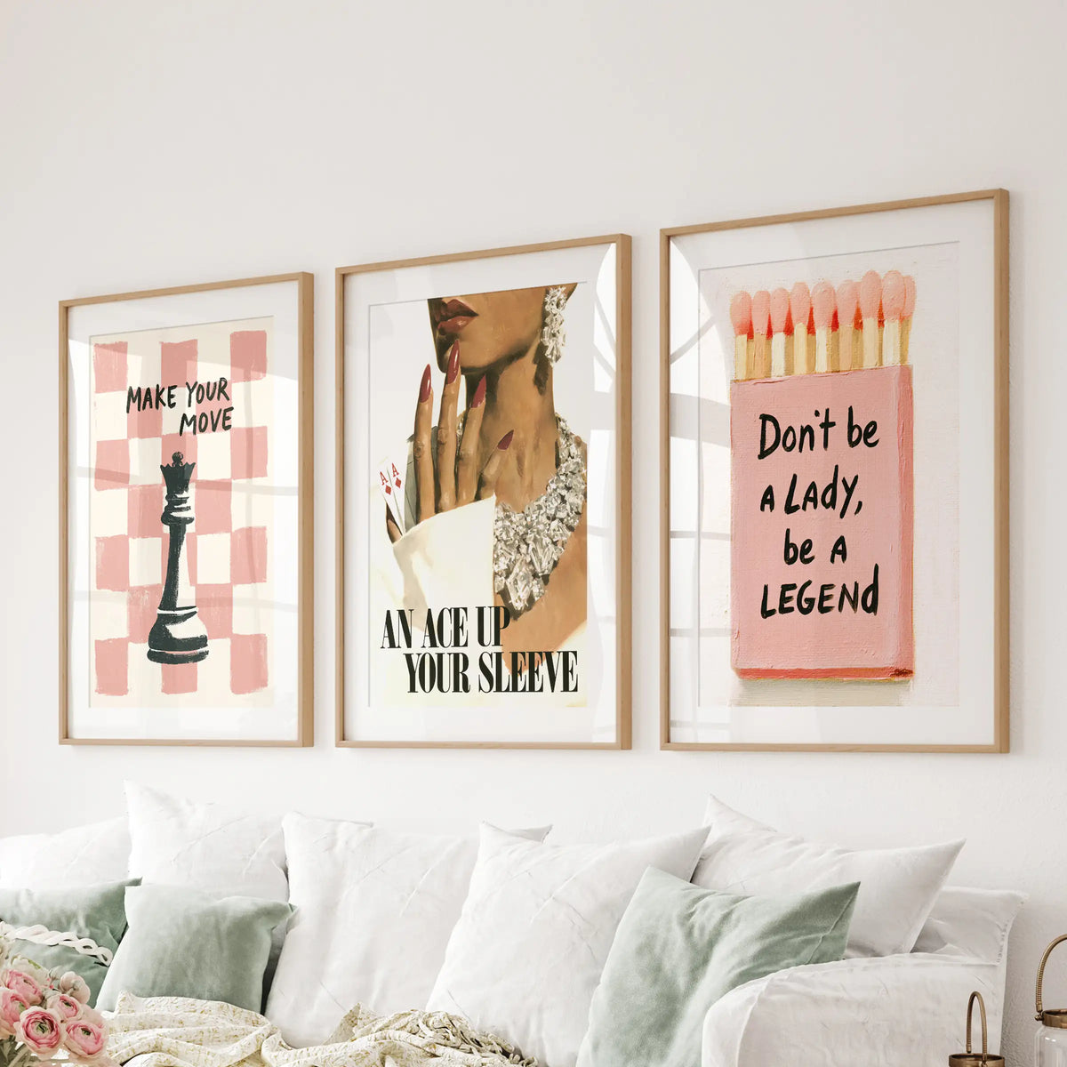 Pink glamour wall art set of three in matted wood frames, arranged above a sectional in the sitting room.