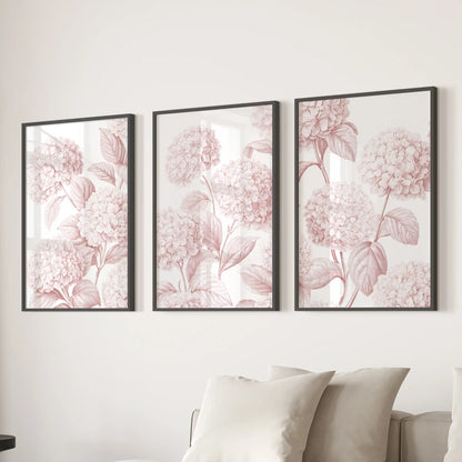 Three pink hydrangea pattern prints in black frames above a sofa.