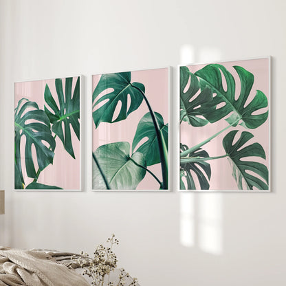 Tropical pink and green foliage 3-print set in white frames hangs beside the bed, delivering gentle botanical wall art that softens the bedroom.