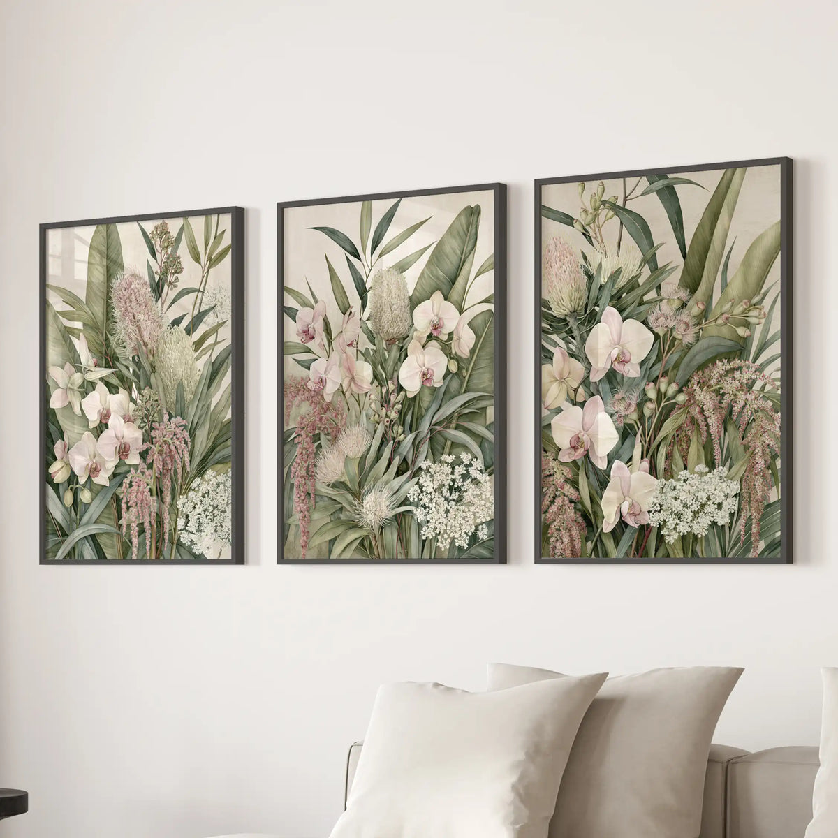 Above a sofa, three black-framed prints show pink orchids among layered green leaves.
