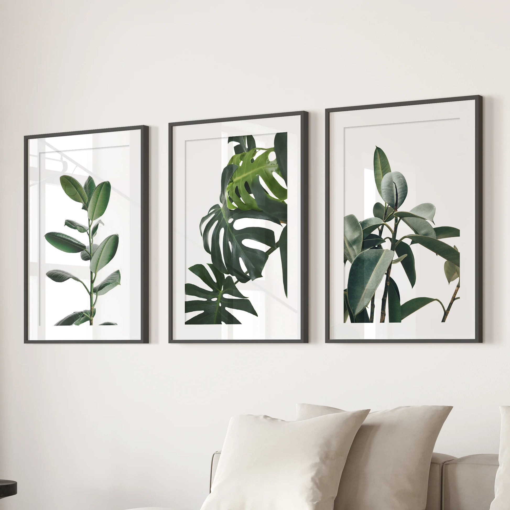 A wall art trio of framed botanical photographs with matte borders gives the lounge a curated, gallery-style accent above the sectional.