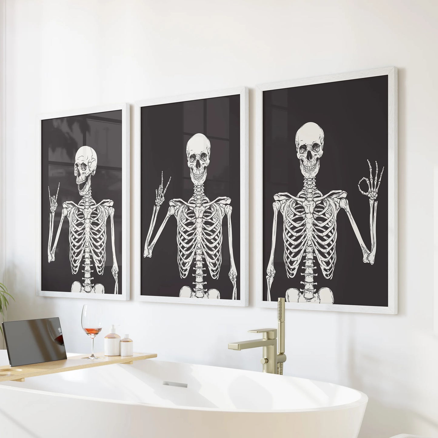 Halloween skeleton art in a 3-piece artwork trio rests in white frames over the bath, bringing cheeky seasonal wall decor to the bathroom.