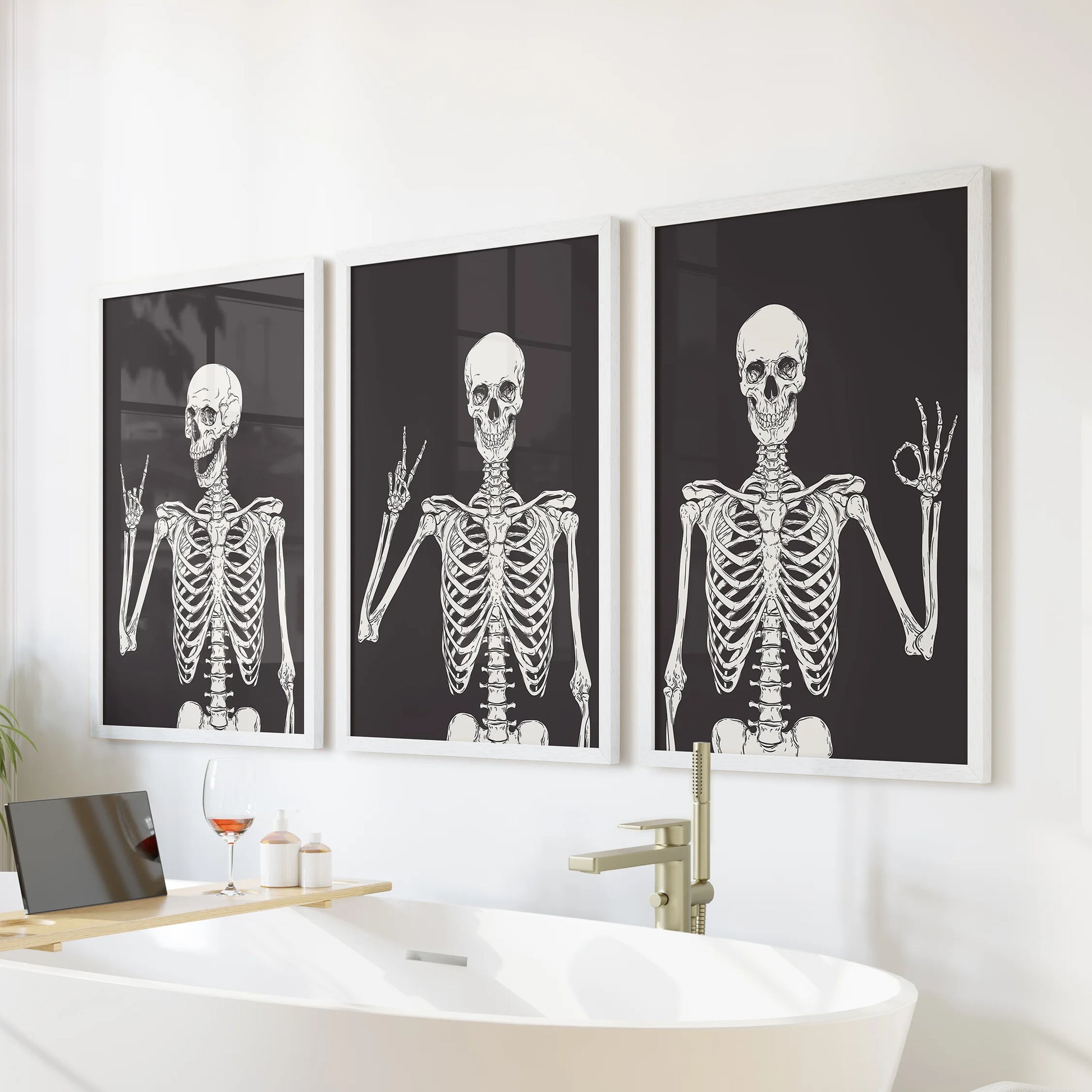 Halloween skeleton art in a 3-piece artwork trio rests in white frames over the bath, bringing cheeky seasonal wall decor to the bathroom.