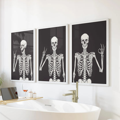 Halloween skeleton art in a 3-piece artwork trio rests in white frames over the bath, bringing cheeky seasonal wall decor to the bathroom.