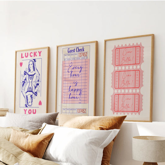 Pink guest check wall prints, a three-piece art set in natural oak frames, stack neatly over the bed’s headboard to lend warm preppy character.