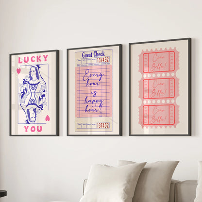 Three pink playing card prints framed in black create crisp wall decor above the living room couch, lending a polished, preppy vibe.