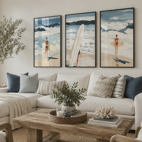 Set of three coastal surfing prints in black frames draw the eye above a white sectional sofa during a smooth cinematic push-in