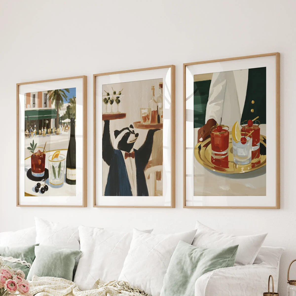 Cocktail drinks in a three-piece wall artwork set, presented in light wood frames with mats over a sectional sofa in the sitting room.
