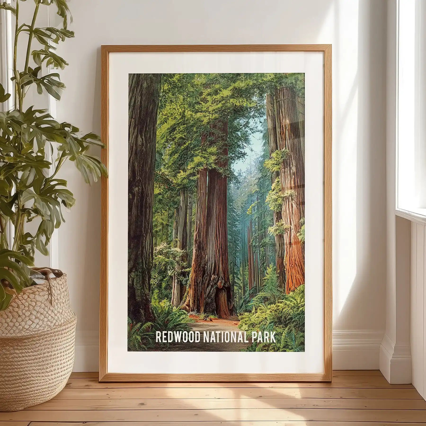 A black-framed wall print of towering sequoias, neatly matted, rests against a bedroom wall for a relaxed, lived-in look.
