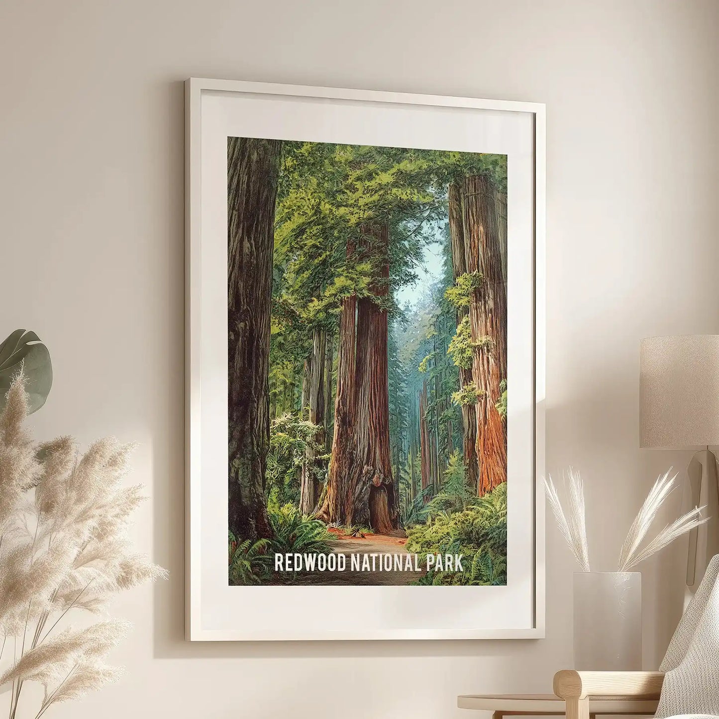 A California redwood forest print in a white matted frame brightens the lounge wall beside a reading chair, airy and calm.