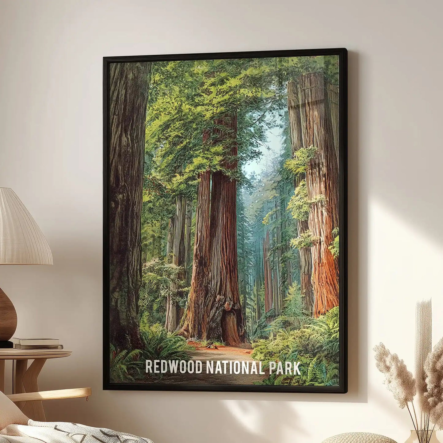 A large black-framed art print of Redwood National Park hangs above a lounge chair, filling the wall with misty redwood scenery.