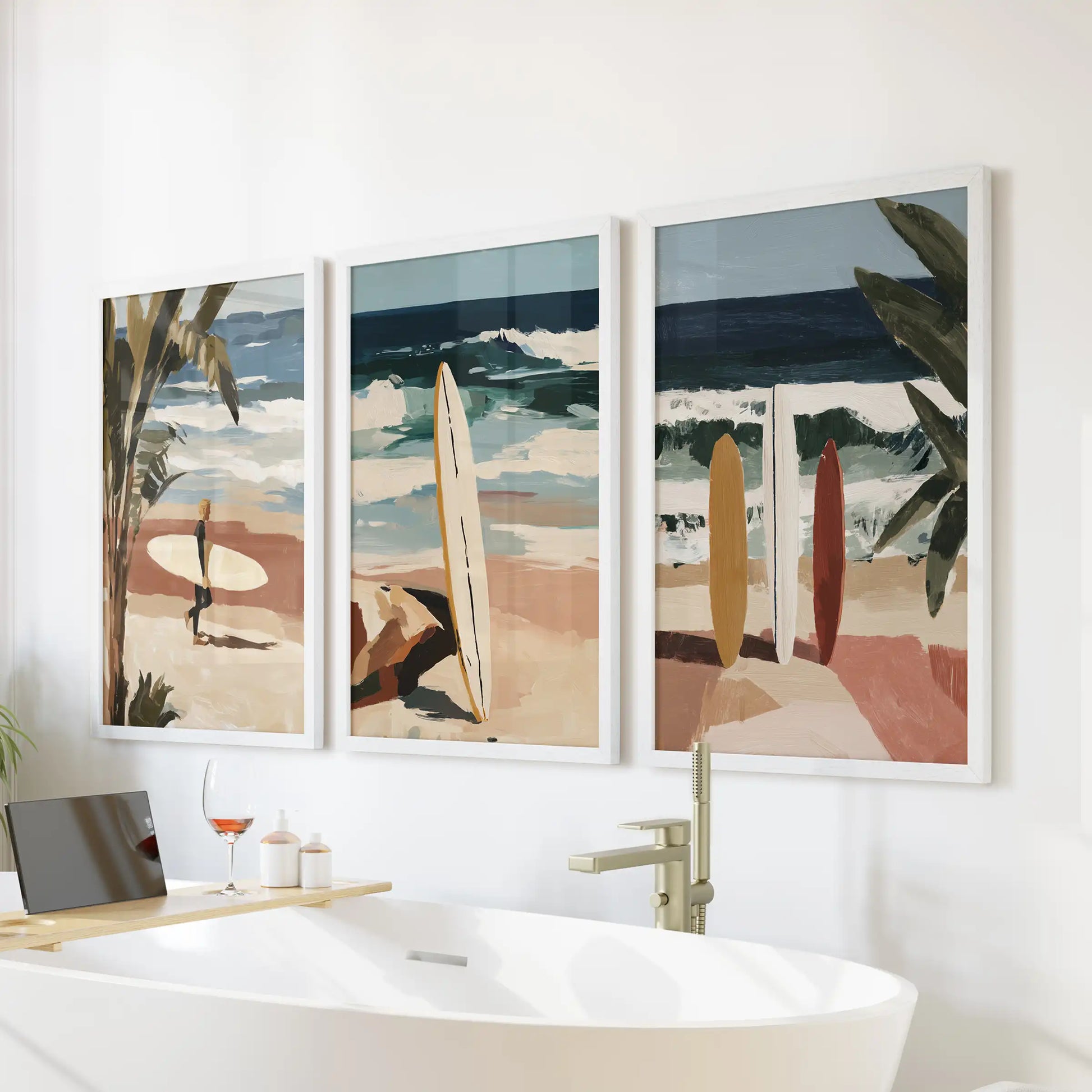 Surfboards three-piece wall art in crisp white frames hangs above the bathtub, adding sun-faded color bars and simple coastal geometry to the bath.