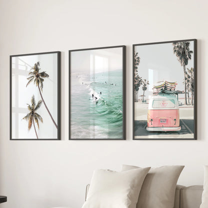 Pink camper van on the beach art triptych brings a sunny focal point over the sectional in the lounge, displayed in sleek black frames.