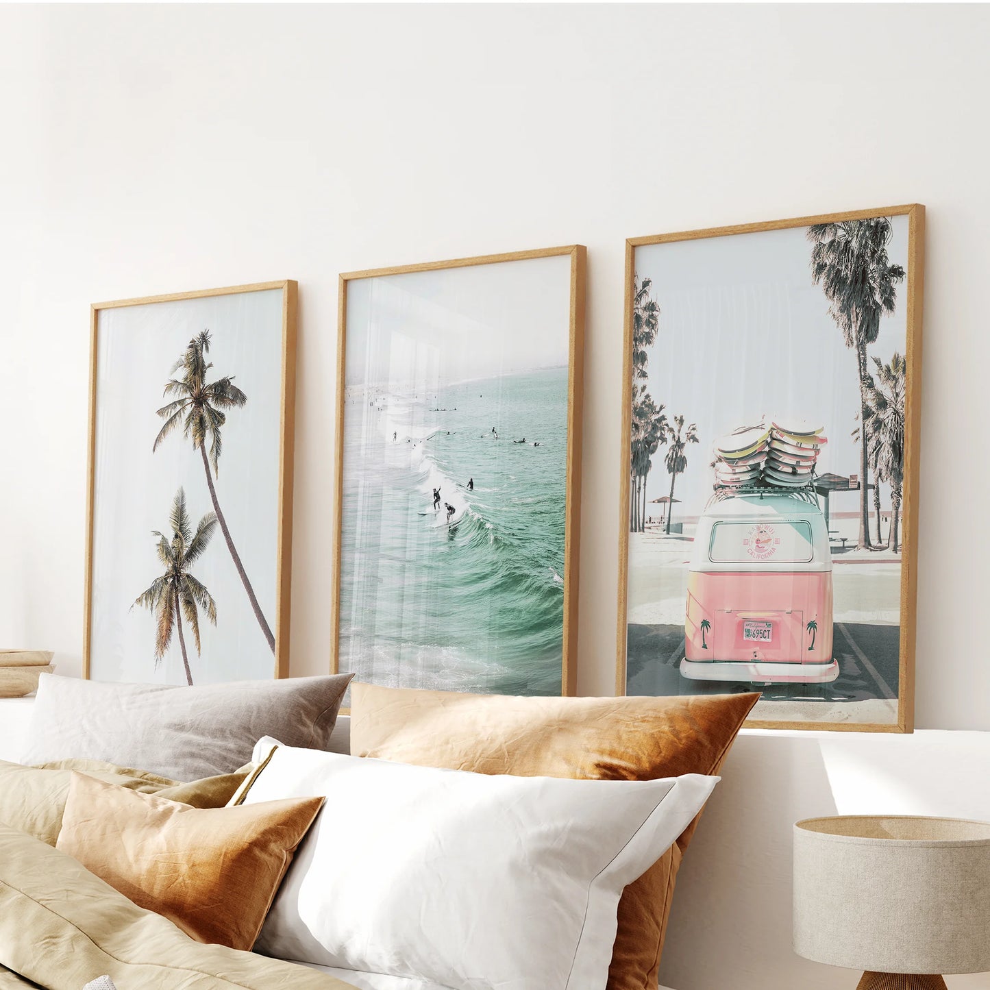 Three oak-framed camper-van prints lend retro charm to the bedroom, forming a cohesive artwork trio over the headboard.