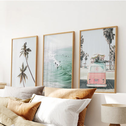 Three oak-framed camper-van prints lend retro charm to the bedroom, forming a cohesive artwork trio over the headboard.