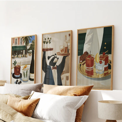 Retro drink illustrations in a three-piece wall decor set, displayed in wood frames above the headboard in a bedroom.