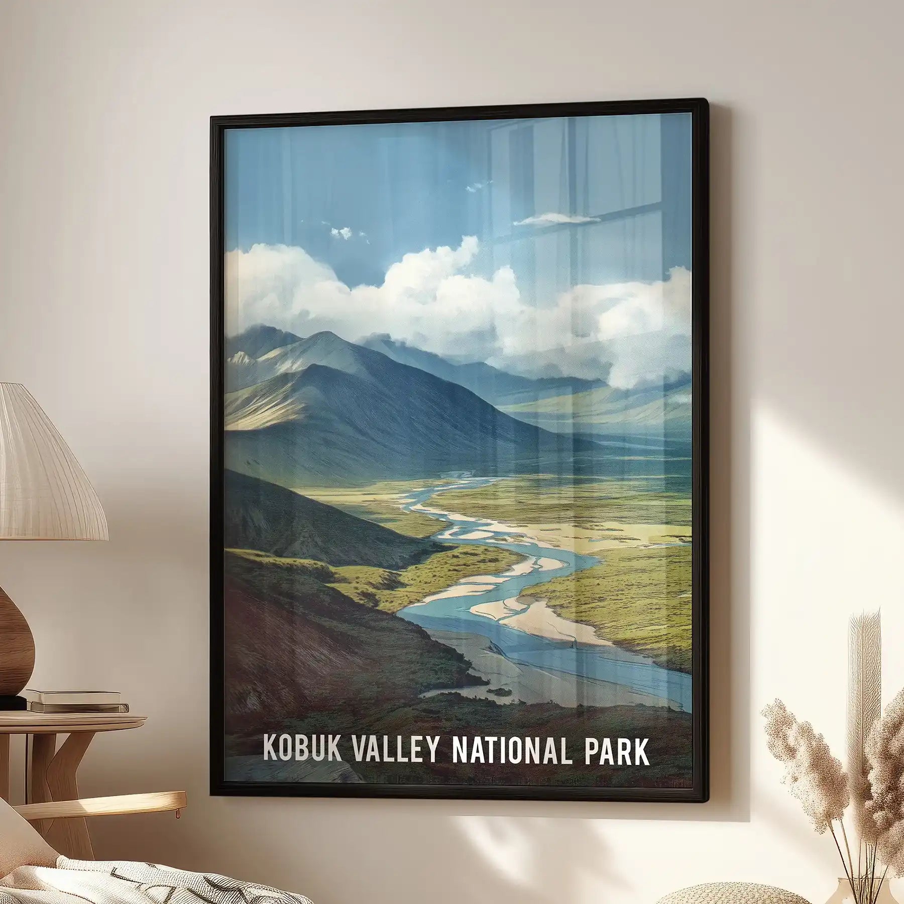 A single-panel wall art piece of a forest and river valley rests in a black frame above the family room lounge seat, adding calm, northern balance.