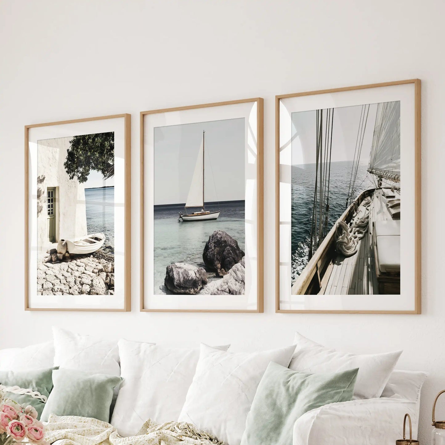 Sailboat photo art, wood-framed with mats, sets the tone in the sitting room; the set of 3 art prints hangs behind the couch for an airy, nautical statement.