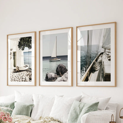 Sailboat photo art, wood-framed with mats, sets the tone in the sitting room; the set of 3 art prints hangs behind the couch for an airy, nautical statement.
