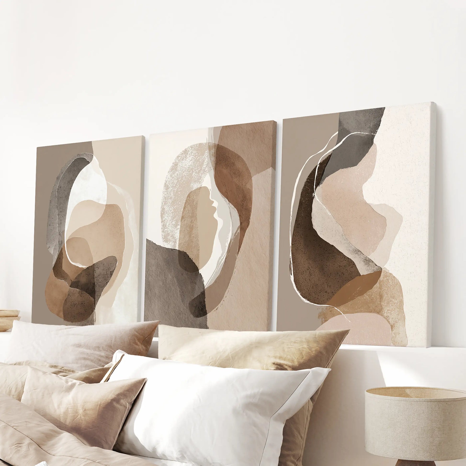 Unframed canvas wall art in three neutral pieces spans the wall above the bed, giving the bedroom a soft boho focal point.