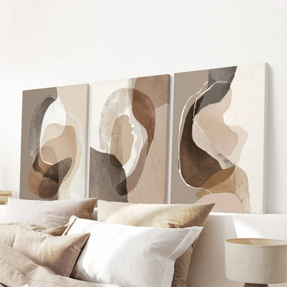 Unframed canvas wall art in three neutral pieces spans the wall above the bed, giving the bedroom a soft boho focal point.