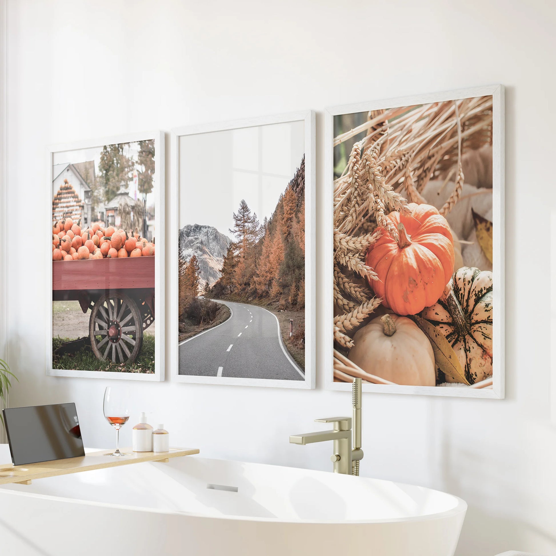 Rustic countryside scene framed poster triptych turns the bathroom serene, white frames lined up over the bath to echo soft hills and quiet fields.