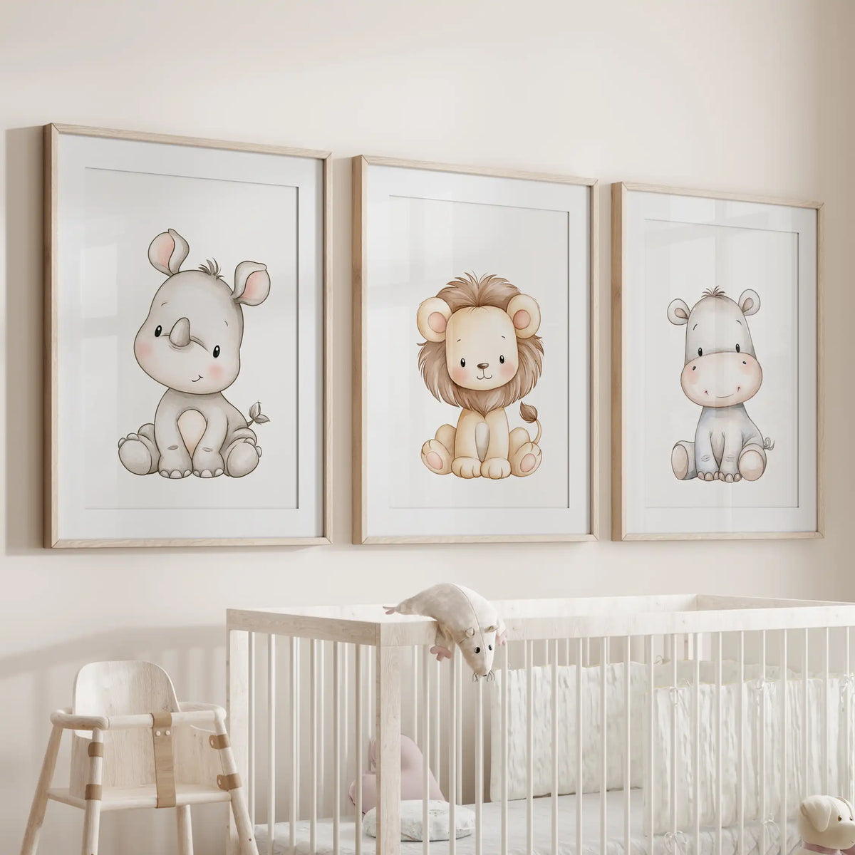 Above a crib, three prints in oak frames with white mats show a pale rhino and gray hippo beside a small lion.