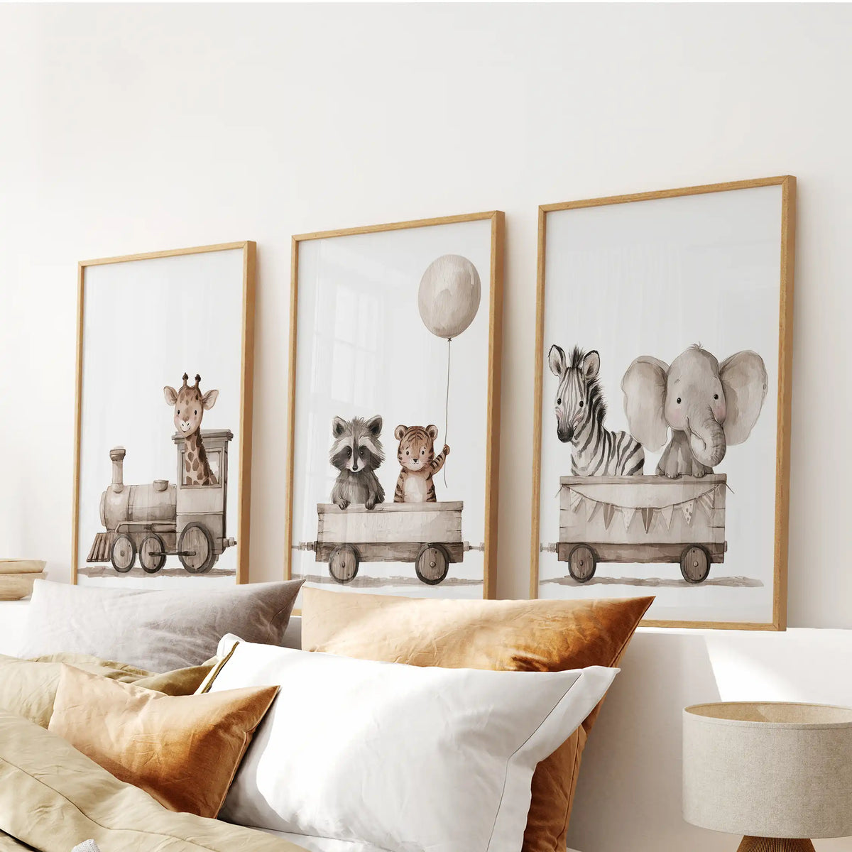 Above a bed, three oak-framed prints show a giraffe-led train of baby animals.