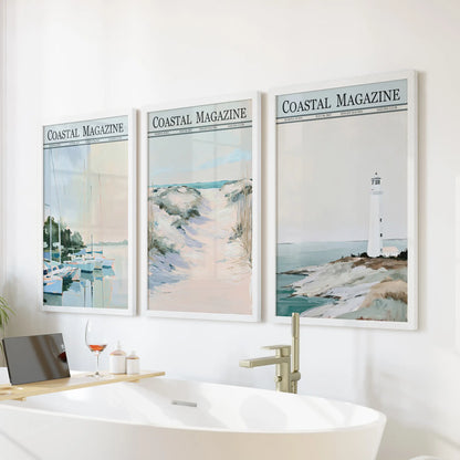 Sailboat marina set of three wall decor prints in white frames, displayed on a bathroom wall above the bathtub with dune and lighthouse views.