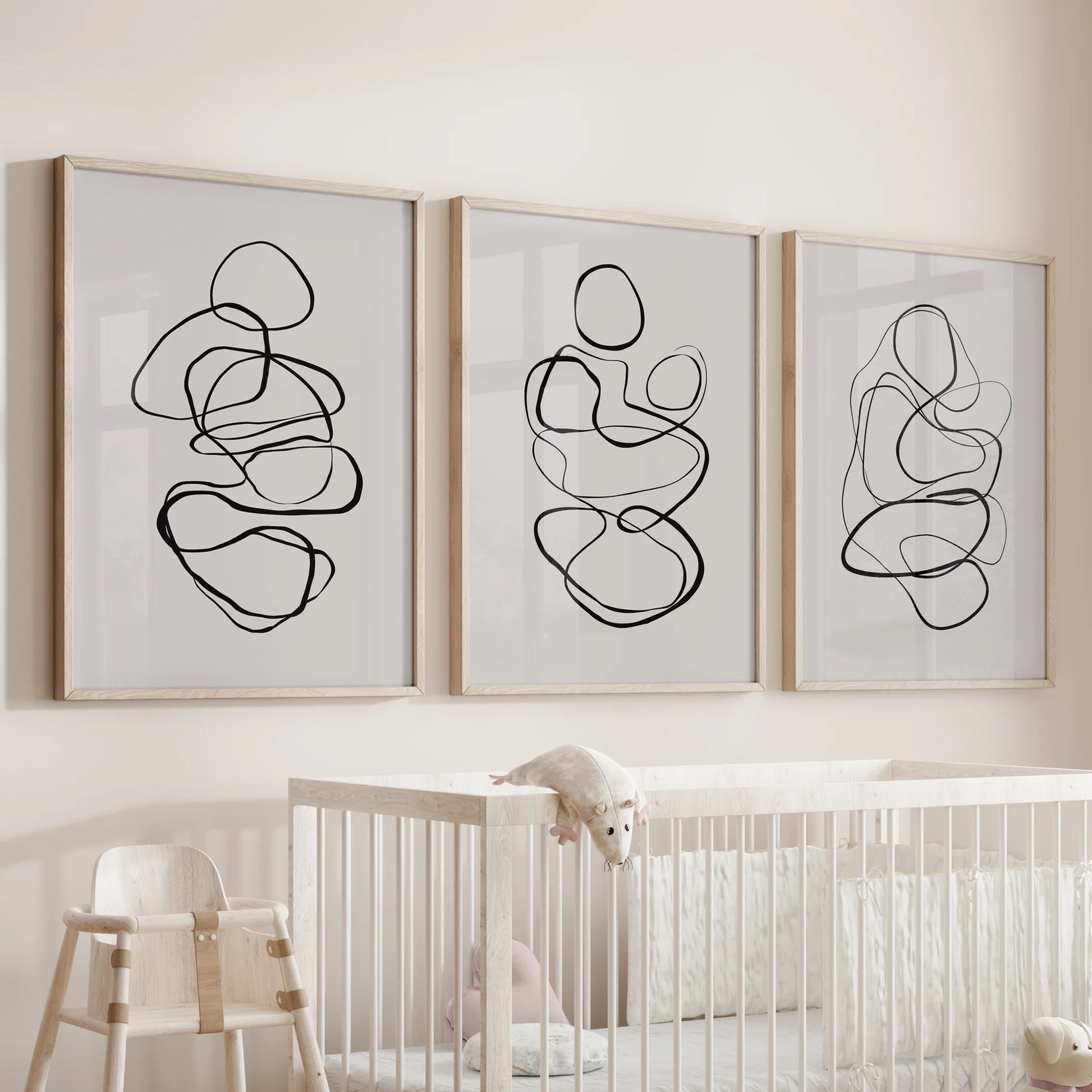 Wood-framed three-panel wall art with one-line drawings brings a sweet, airy touch above the baby’s crib.