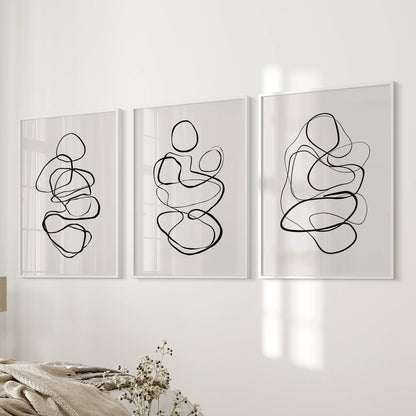Neutral abstract shapes arranged as a 3-piece poster set are white framed to create calm, contemporary wall art across the bedroom wall.