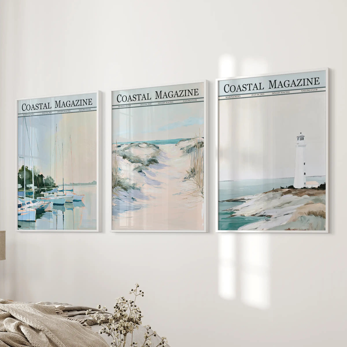 Seaside dunes set of 3 wall art prints in white frames, arranged on the bedroom wall next to a bed and paired with sailboat and lighthouse scenes.