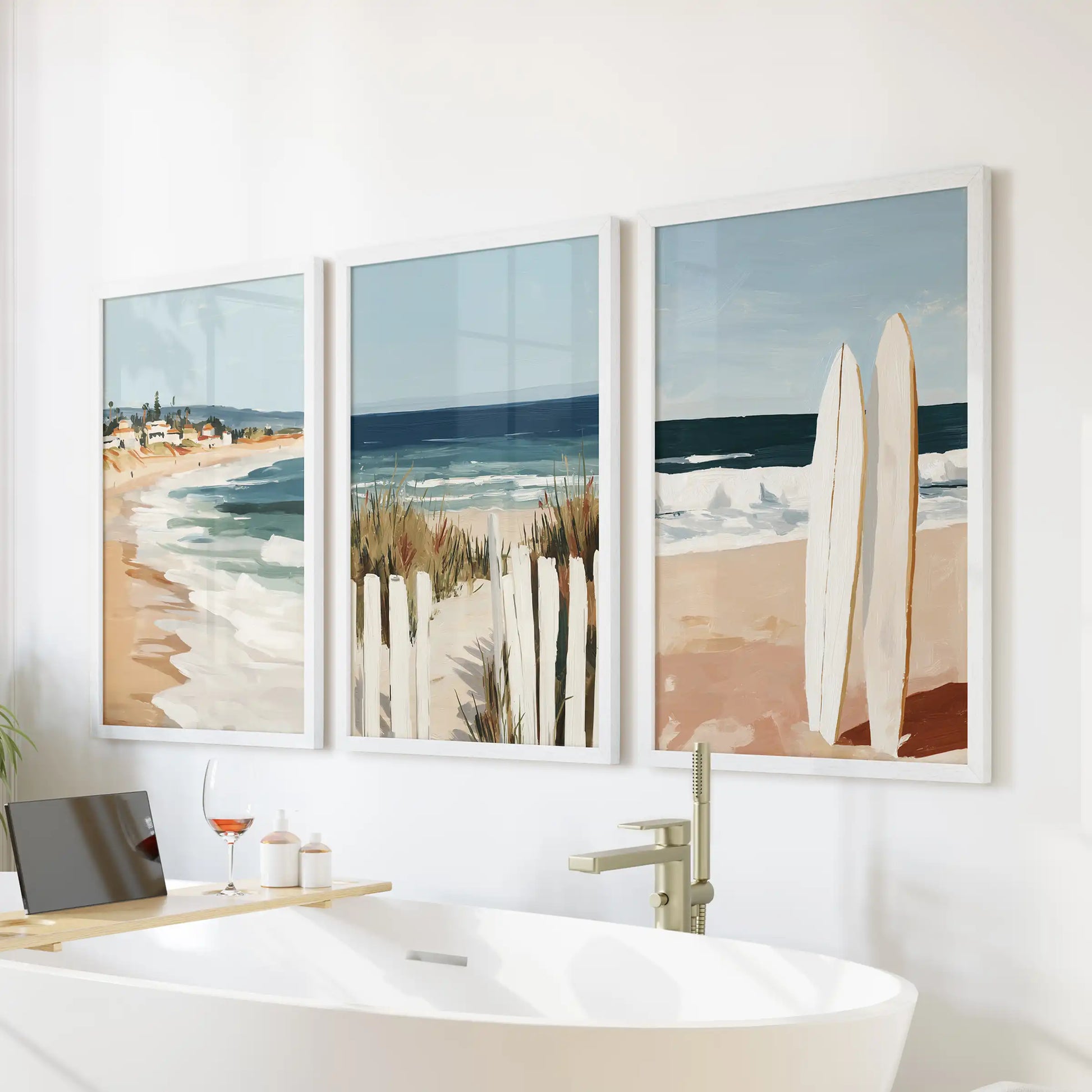 Ocean landscape three-piece art set in white frames rests serenely over a freestanding tub, refreshing the bathroom with coastal light.