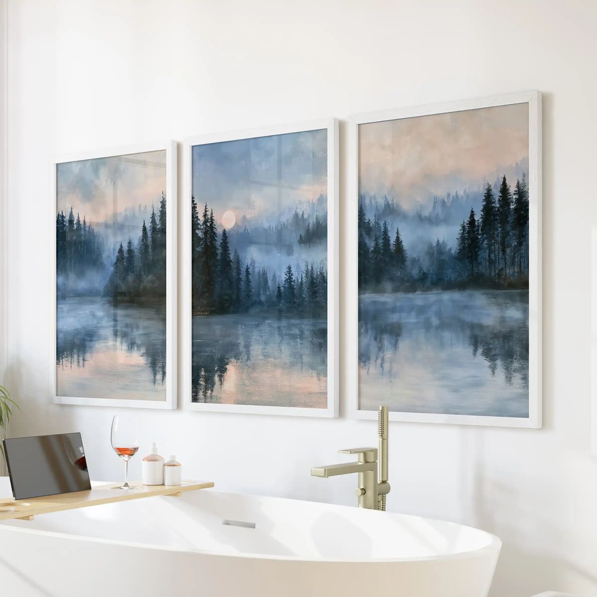 Three-piece impressionist woodland artwork in crisp white frames hangs above the bathtub, bringing dreamy pines and hushed blues to the bathroom.